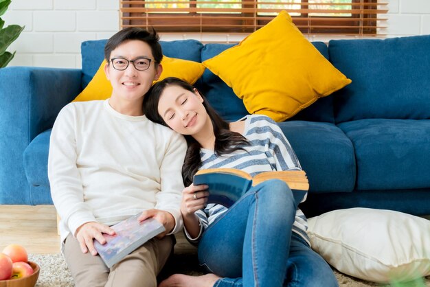 Sweet lovey asian family couple sit talk good conversation on sofa in living room house background