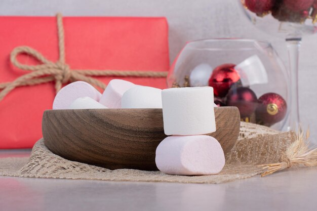 Free photo sweet marshmallows on wooden board on burlap