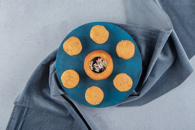 Sweet mini cake with jelly and biscuits on blue board. High quality photo