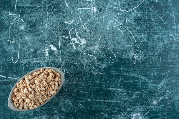 Sweet muesli in a bowl , on the blue background. High quality photo