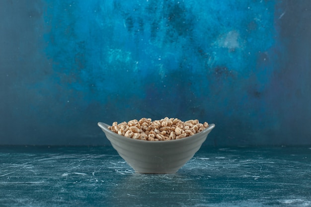 Sweet muesli in a bowl , on the blue table. 
