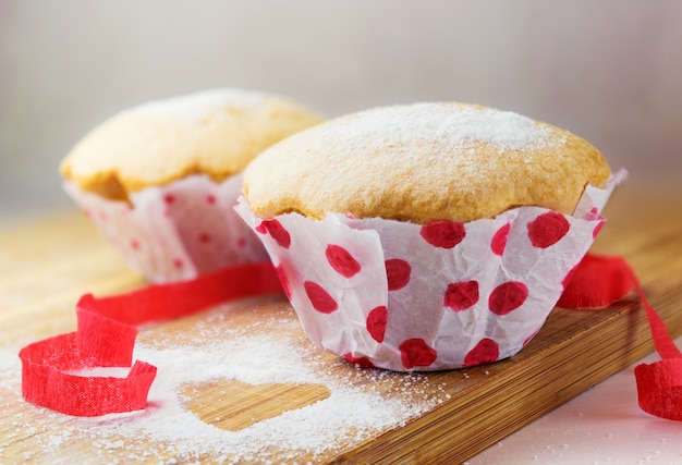 Sweet muffin with sugar and red ribbon decoration