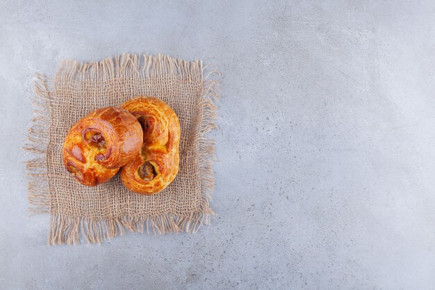 Sweet pastries placed on a sackcloth surface.