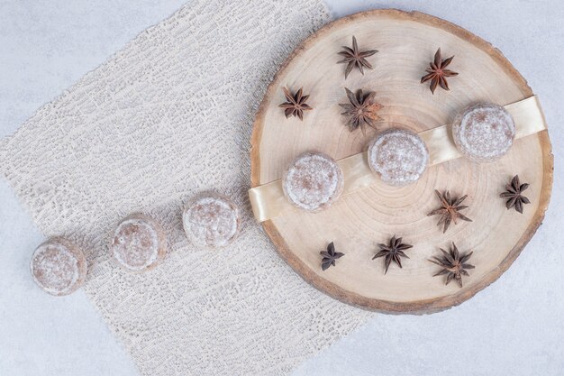 Sweet pastries with dried star anise on wooden plate