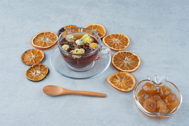 Sweet pastry with dried orange and cup of herbal tea on marble background. High quality photo