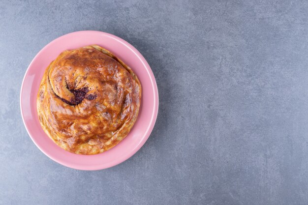 Sweet pie on a plate on marble table.