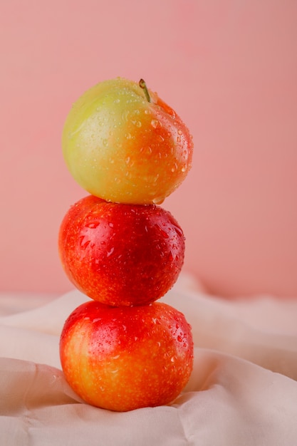 Sweet plums on textile and pink surface