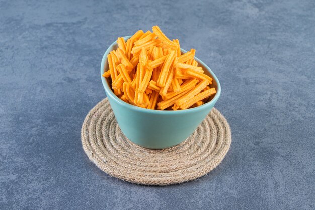 sweet potato fries in a bowl on trivet , on the marble background.