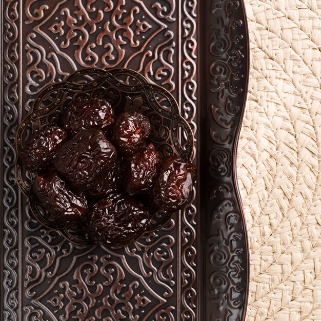 Sweet prunes on saucer against tray and mat