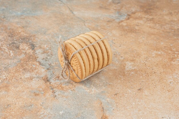 Сладкое круглое печенье в веревке на мраморном фоне