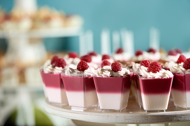 Free photo sweet souffle decorated with raspberry and whipped cream on the blue cackground. delicious dessert for restaurant catering or candy-bar.