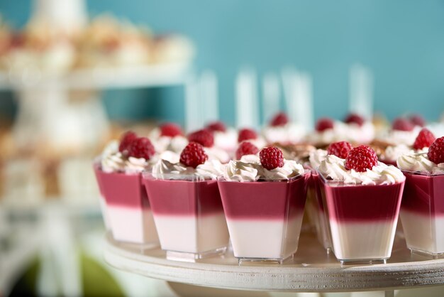 Sweet souffle decorated with raspberry and whipped cream on the blue cackground. Delicious dessert for restaurant catering or candy-bar.