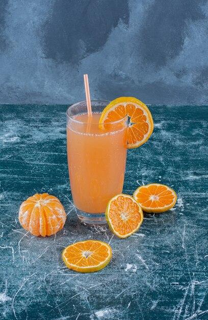 Sweet tangerine and juice on the blue background. High quality photo