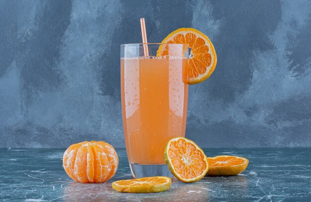 Sweet tangerine and juice on the blue table.