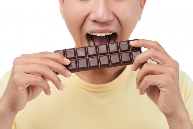 Free photo sweet tooth biting chocolate bar