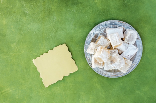 Sweet Turkish delight on plate with small paper 