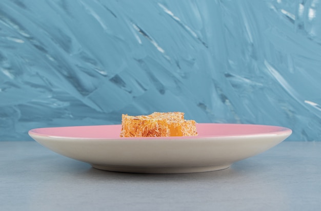 Free photo sweet yellow turkish delight on the marble, on thee blue background. high quality photo