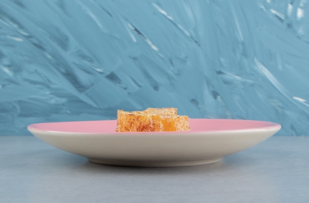 Sweet yellow Turkish delight on the marble, on thee blue background. High quality photo