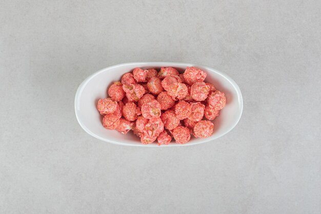 Sweetened popcorn in an oval bowl on marble.