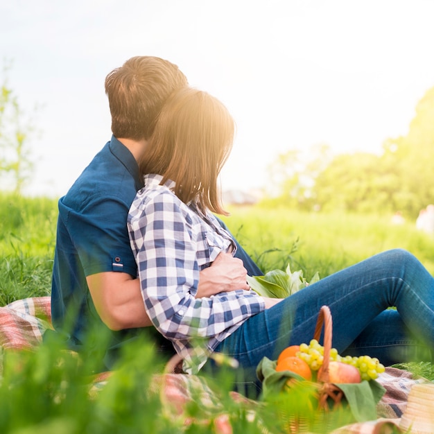 Foto gratuita innamorati che si divertono a fare picnic sul campo