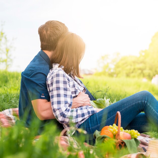 Sweethearts having nice time at picnic on field