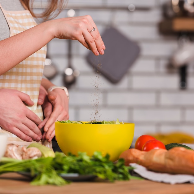 Sweethearts preparing vegetable salad in kitchen