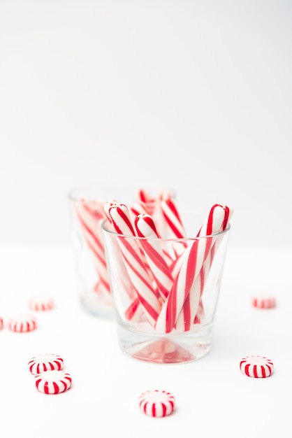 Sweetmeat on table and sticks candies in glass