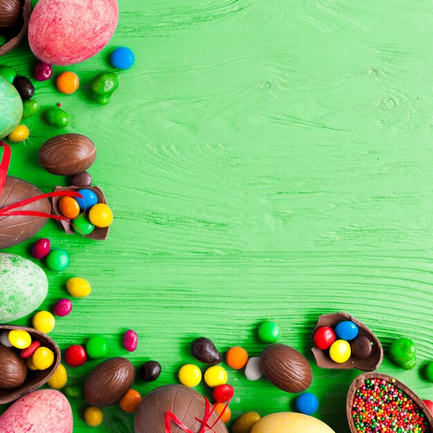 Sweets and eggs on green background