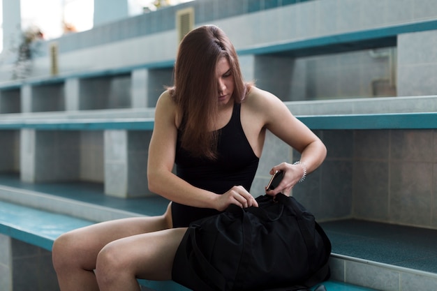 Swimmer searching in sports bag