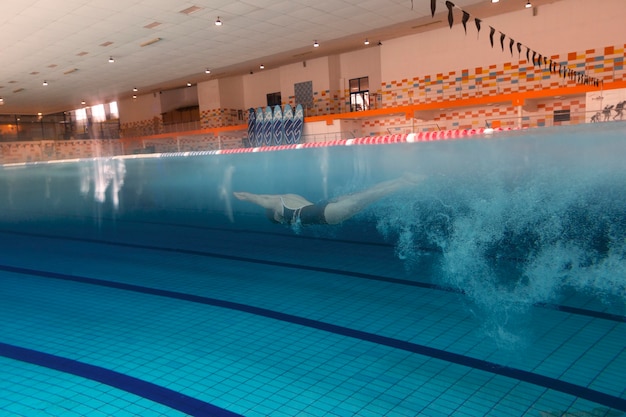 Swimmer with equipment in pool long shot