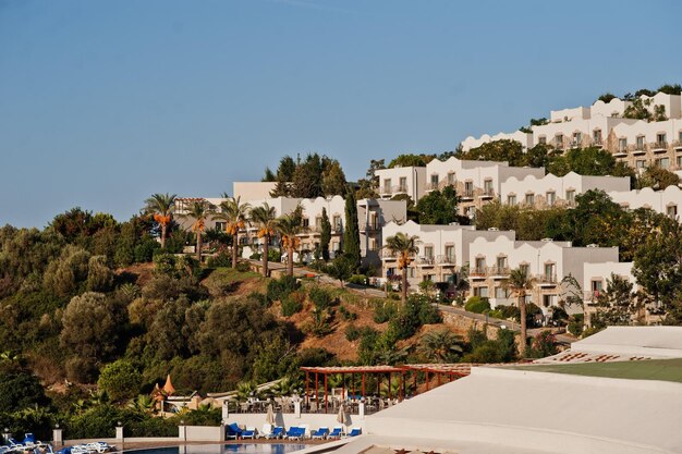 Swimming pool with cottages buildings in sunny day at mediterranean summer resort hotel in Turkey Bodrum