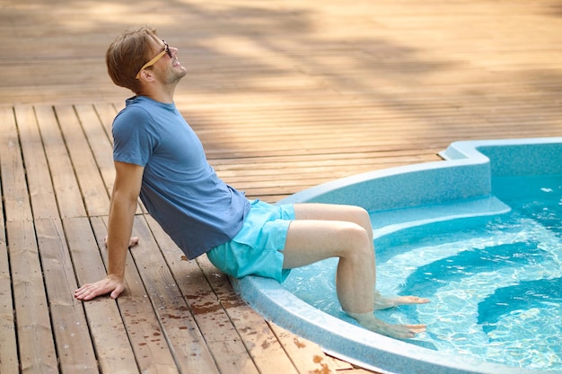 At the swimming pool A young man in blue swim shorts at the swimming pool