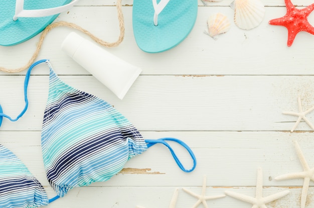 Free photo swimsuit with sunscreen cream and sea stars