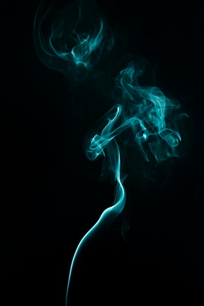 Swirl of blue steam smoke on black background