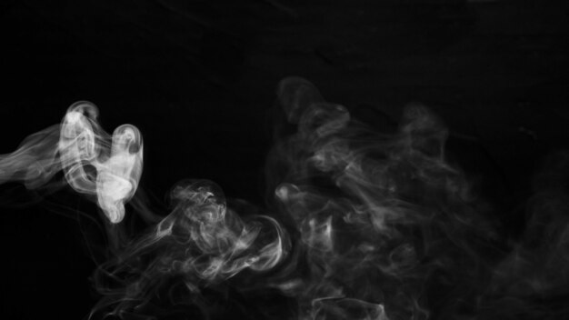 Swirl of white smoke against black dark background