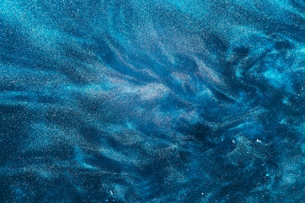 Swirls of azure paint on water