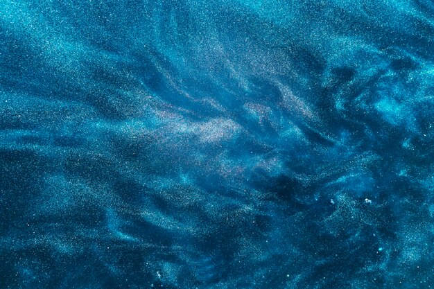 Swirls of azure paint on water