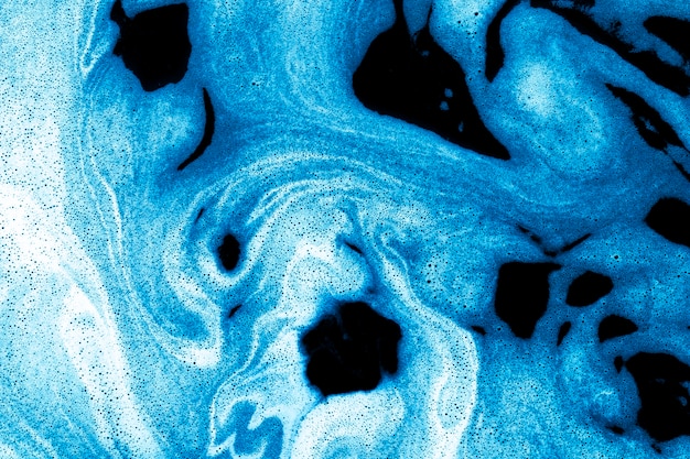 Free photo swirls of foam on blue liquid