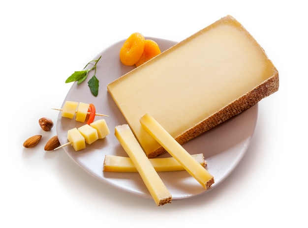 Swiss Gruyere cheese in a plate on white background