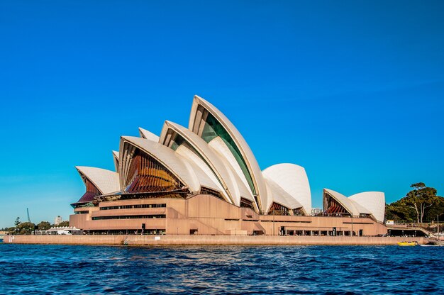 Free photo sydney opera house near the beautiful sea under the clear blue sky
