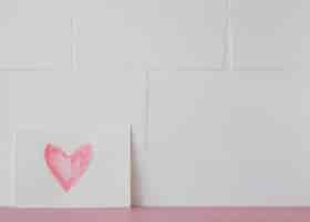 Free photo symbol of heart on white paper near wall