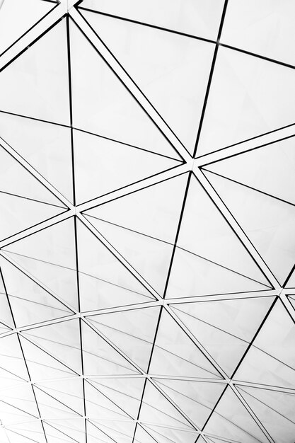 Symmetric triangle pattern on windows with a view of a grey cloudy sky