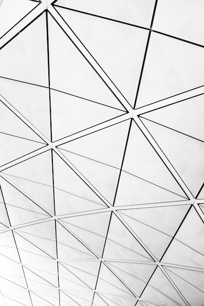 Symmetric triangle pattern on windows with a view of a grey cloudy sky