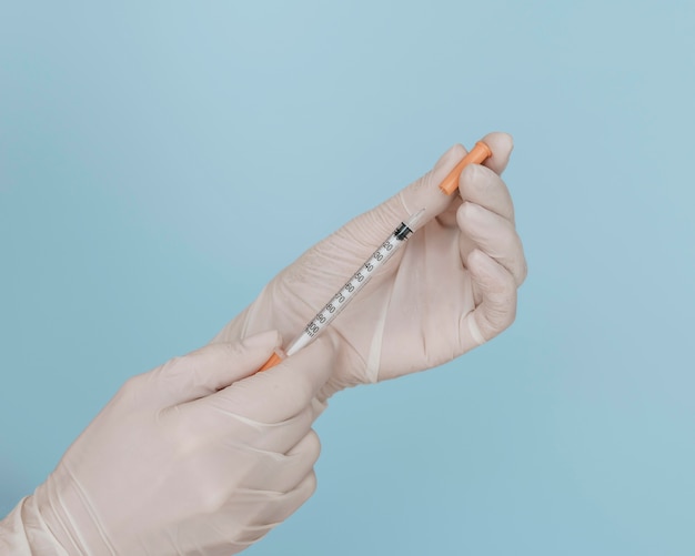 Free photo syringe in hands wearing gloves