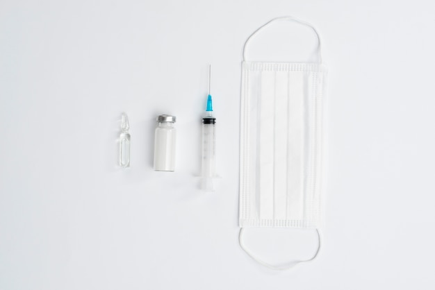 Free photo syringe and mask on white background