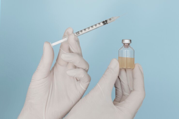 Free Photo syringe and vaccine bottle in hands wearing gloves