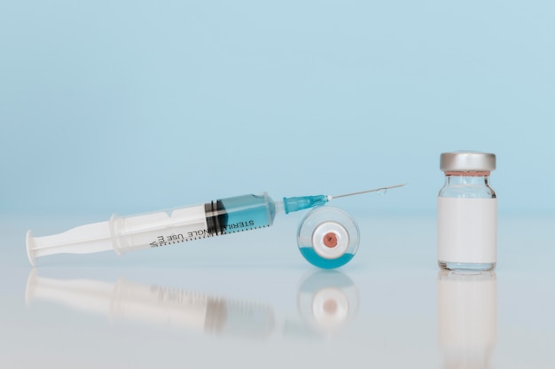 syringe and vaccine bottles on table