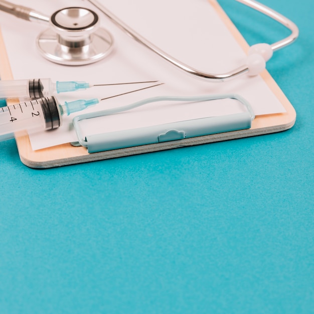 Free photo syringes and stethoscope on clipboard