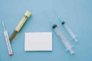 Free photo syringes, thermometer and sample with business card