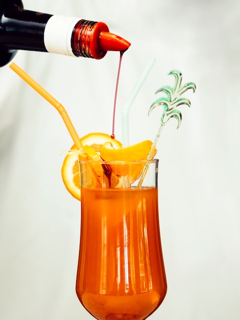 Free photo syrup pouring into tropical cocktail